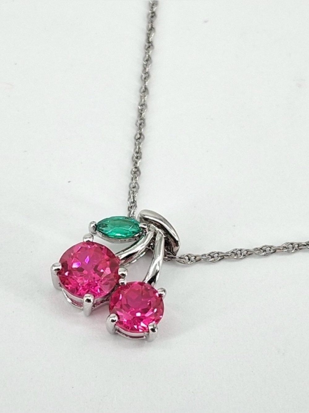 Sterling silver 925, 18”. Necklace Cherry pendant w/L emerald and ruby. 2.5 gr.